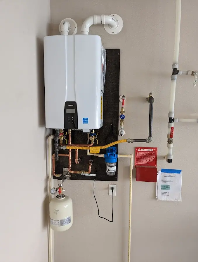 Professional plumber installing copper piping in a Moultonborough home